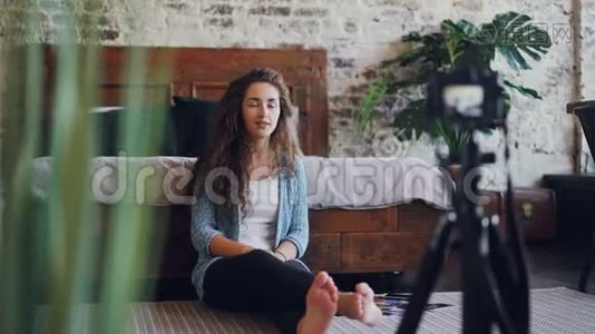 情绪化的年轻女性vlogger正在用专业的相机为互联网博客说话和手势录制视频。 女孩视频
