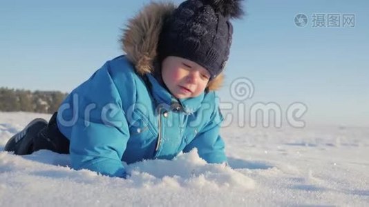 冬天特写户外可爱梦幻的小男孩肖像，快乐的小男孩在雪地里玩耍，户外。视频