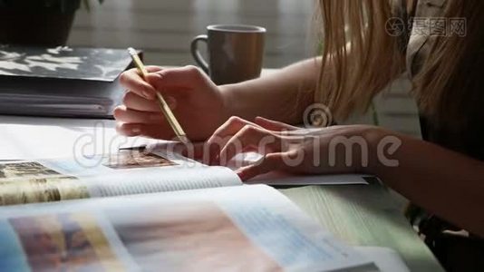 在家工作。 年轻漂亮的女人正在靠窗的桌子上工作，在房子的特写镜头里。 现代视频