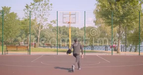 年轻活跃的非裔美国男篮球运动员在户外向篮筐投掷球的特写镜头视频