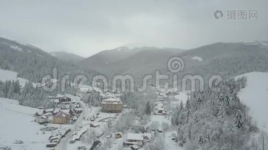 飞越喀尔巴阡山的一个村庄。 鸟`山上白雪覆盖的房子的视野。 乡村景观视频