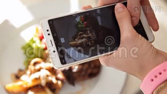 女人用智能手机拍照晚餐食物。 特写视频