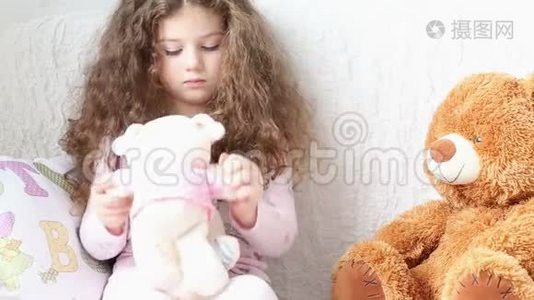 小女孩在沙发上玩玩具熊视频
