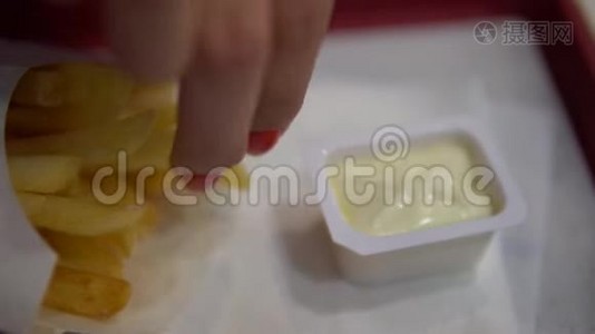 女性手拿炸薯条。 把女人的手拿上炸薯条。视频