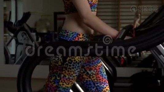 健身房里的一个女孩在跑步机上行走时感到温暖视频