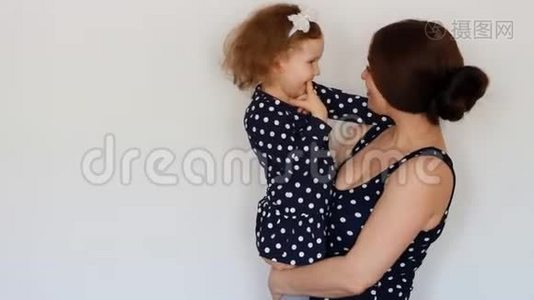 一个幸福的母亲抱着一个孩子，表达母爱。 拥抱和亲吻。视频