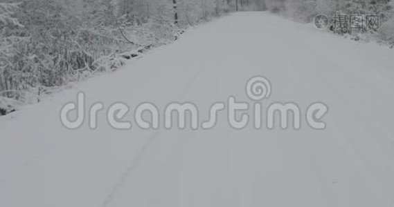 在大雪纷飞的冬日乡间小路上缓慢平稳的行驶视频