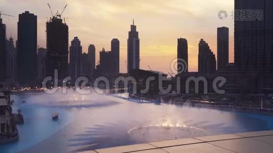 迪拜喷泉是世界上`最大的设计喷泉系统日落背景上的Burj Khalifa湖股票视频