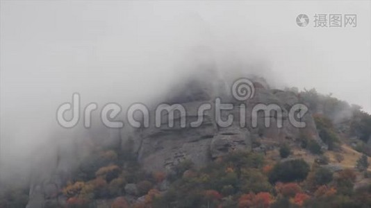 在山脉上空移动的云。 中枪。 一座崎岖不平，多岩石的山峰和景观笼罩在浓雾和云层中。视频