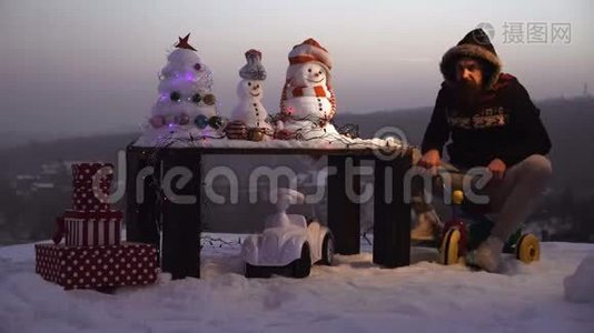 惊讶的人骑三轮车在雪景上。 冬日里的雪人和圣诞树。 圣诞节和新年的乐趣视频