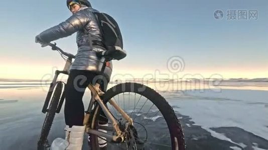 轮胎的视图。 拍摄60fps动作摄像头。 女人在冰上骑自行车。 冰的贝加尔湖。 轮胎视频