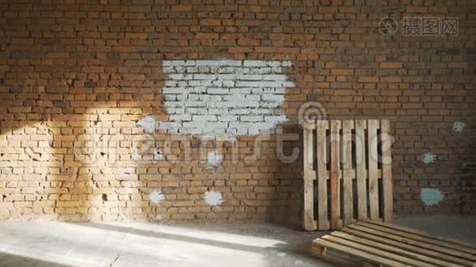 一个年轻的女孩用滚筒在她的房子里画一堵砖墙。 用滚筒粉刷墙壁。 把裸露的墙壁漆成视频