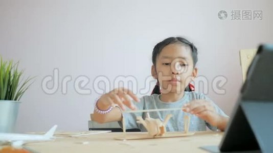亚洲小女孩制作飞机木制模型，选择焦点浅场深视频