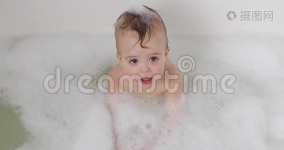 婴儿在充满泡沫的浴缸里向上看视频
