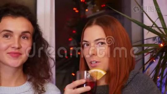 在一个节日的聚会上，带着一杯酒的女孩在交流视频