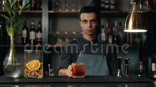 把酒保的手和葡萄柚一起准备黑色鸡尾酒。 他正在把柚子皮放进里面视频