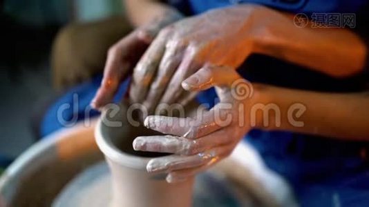 波特和他的女学生的手。 男人和女人一起工作，在陶工轮上制造粘土制品视频