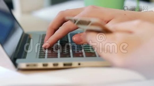女性手在手提电脑键盘上输入信用卡号码视频