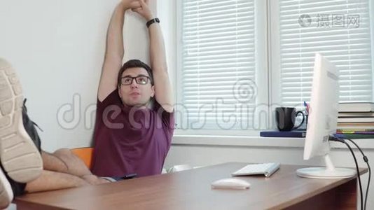 年轻的商人用电脑完成他的工作，并在办公室里伸展手臂。 在办公室短暂休息。 4k视频