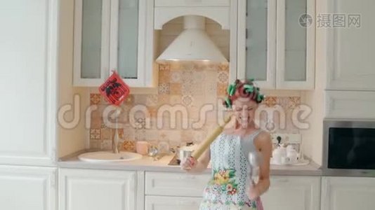 有趣的女人在家厨房做饭时用擀面杖跳舞唱歌视频