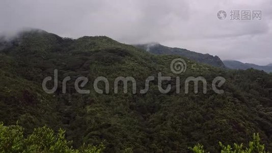 岛上青山在多云多雨的天气下，山顶隐藏在白云下。视频