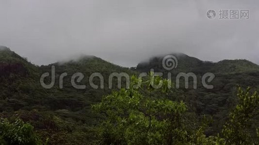 岛上青山在多云多雨的天气下，山顶隐藏在白云下。视频