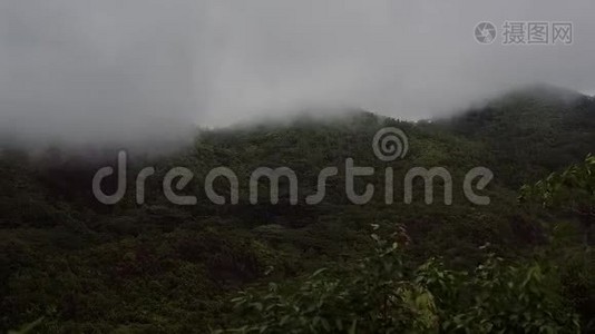 岛上青山在多云多雨的天气下，山顶隐藏在白云下。视频