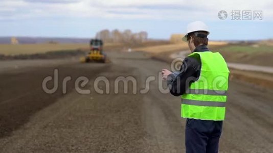 工程师以道路施工为背景，看了看碑上的施工方案。视频