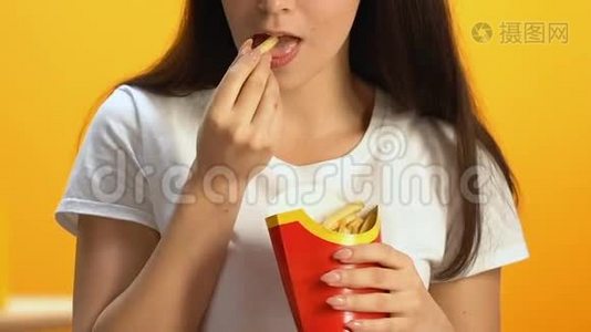 在快餐店吃高脂肪炸薯条的年轻女人，不健康的饭菜视频