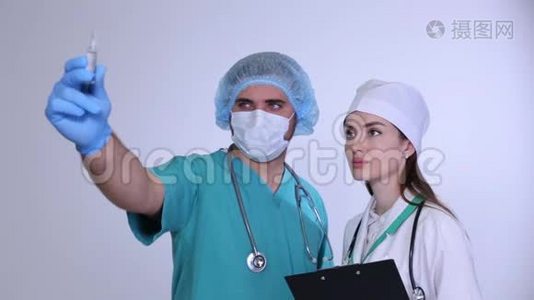 男性医疗顾问和年轻的女性医生看安瓿。视频