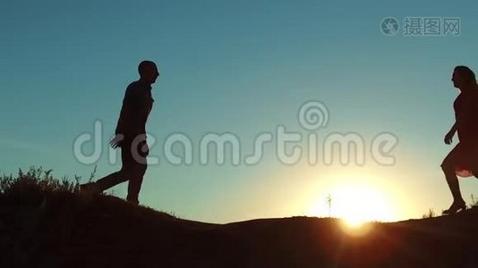 一对情侣在宠物狗的剪影旁边朝对方跑去。 慢动作视频。 男人拥抱女孩扭视频