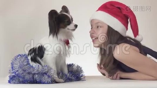圣诞老人戴着圣诞老人的帽子、戴着狗的美丽的少女在新年里`他的小罐子快乐地玩耍视频