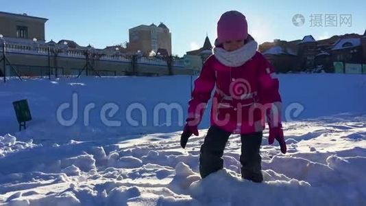 孩子玩冬天有趣的游戏。 在阳光下玩雪的女孩视频