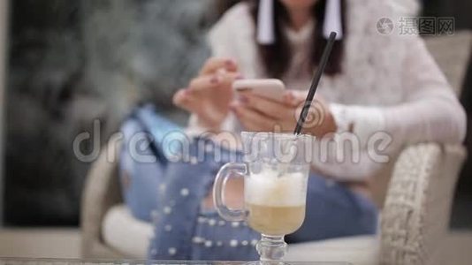 咖啡馆里的女孩用智能手机特写视频