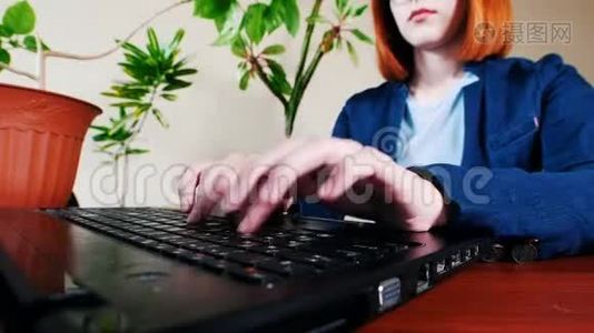 戴眼镜的年轻女子在办公室的笔记本电脑上打字视频