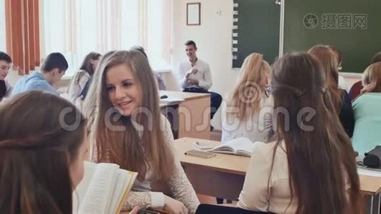 学生在坐在桌子上的课之间交流。 俄罗斯学校。视频