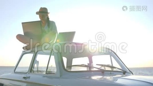 可再生能源，女性坐在经典的老式汽车上，笔记本和电池在背景天空阳光下视频