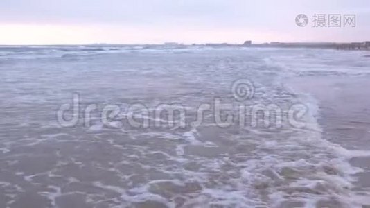 大海里波涛汹涌. 美丽的海景与沙滩和海岸小镇背景在日落。视频