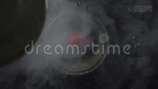 碗里草莓上流动的液体和烟雾的俯视图。视频