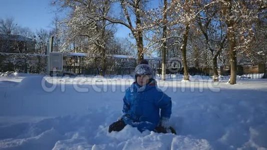 男孩正在雪地里玩耍，慢慢地从雪地里舔嘴唇视频