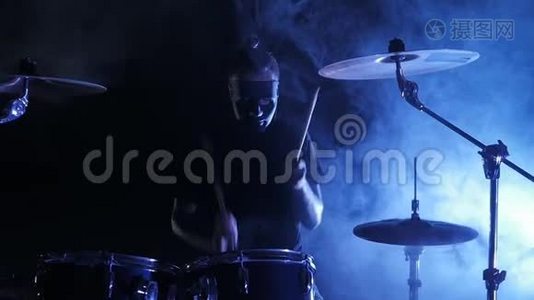 面具鼓手在舞台上演奏架子鼓. 以慢动作射击。 音乐视频朋克，重金属或摇滚团体。视频