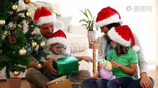 可爱的家庭在地板上打开圣诞礼物视频
