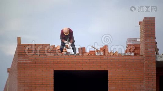 工人用砖头砌墙. 建筑造砖的建设者。 建筑工地的建筑工人做砖视频