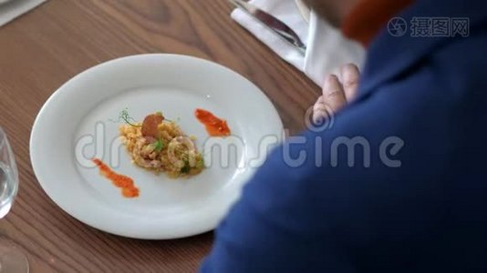 男士饮食博主在餐馆里用叉子和刀子吃牛腿菜视频