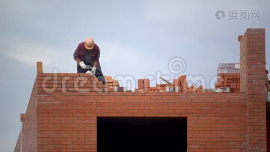 工人用砖头砌墙. 建筑造砖的建设者。 建筑工地的建筑工人做砖视频