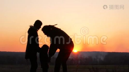 妈妈，爸爸和女儿在日落背景下。视频