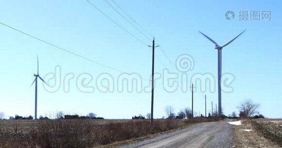 沿着宁静的乡村道路行驶的风力涡轮机视频