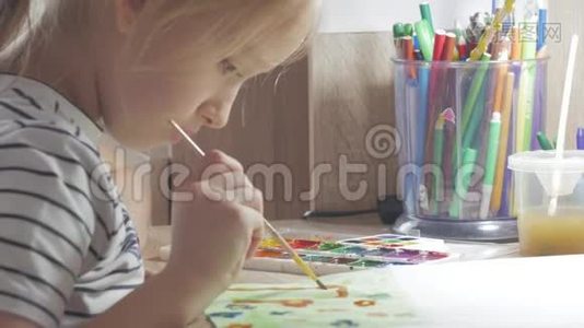 十几岁的女孩在家里从事创意，在房间的一张桌子上画水彩。 幼儿绘制俯视图.. 艺术作品视频