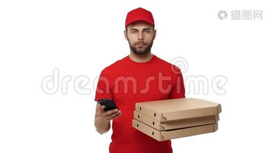 送货男孩穿着红色制服，拿着一叠比萨饼盒，在手机上检查订单。 孤立于白色之上视频