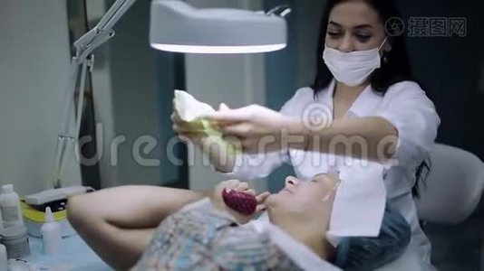 美容师从一个皮肤有问题的年轻女孩脸上摘下面具视频